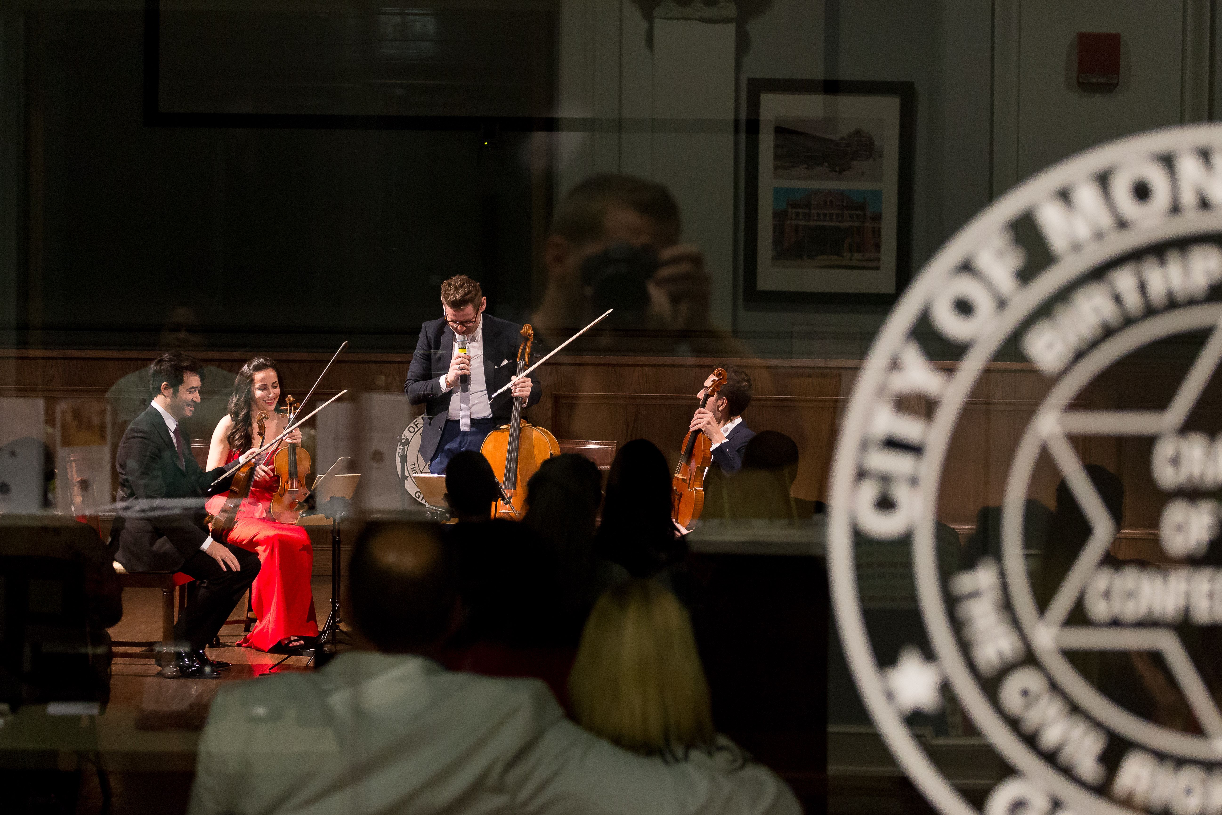 Musicians playing stringed instruments with a seal of the City of Montgomery in the foreground